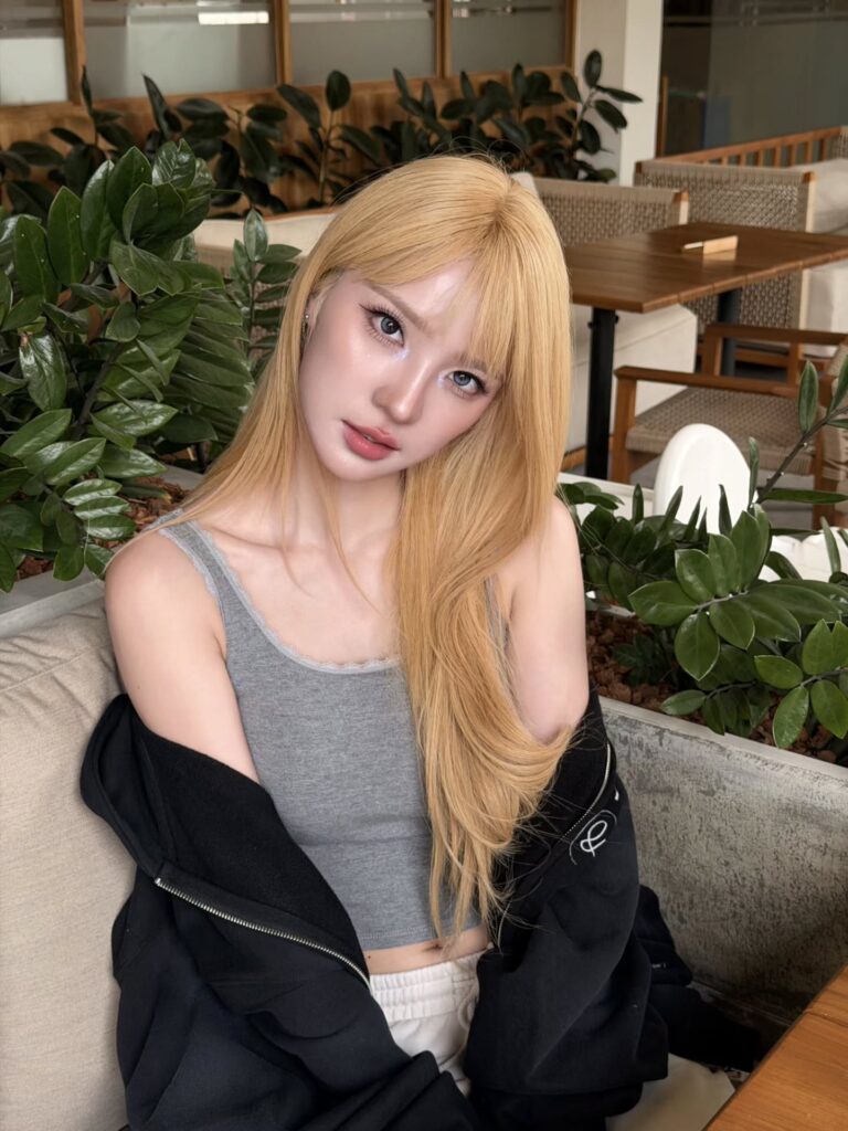 แจน พลอยชมพู ศุภทรัพย์ ในลุคเสื้อสีเทาและแจ็กเก็ตสีดำ